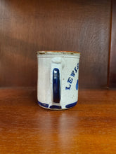 Load image into Gallery viewer, Pottery mug handle with a navy blue paint stroke design.
